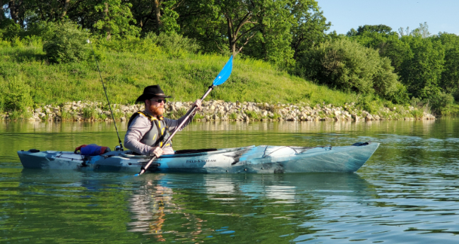 Kayaker with fishing pole paddling on Dale Maffitt Reservoir