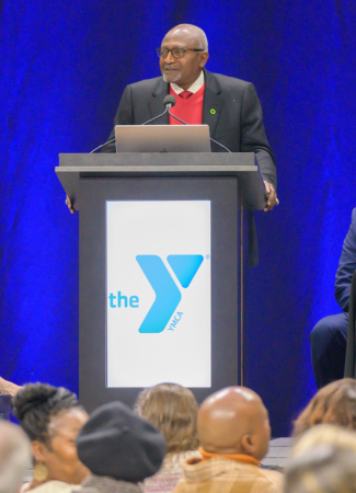 Dr. Robert Bullard stands behind a podium with a blue backdrop