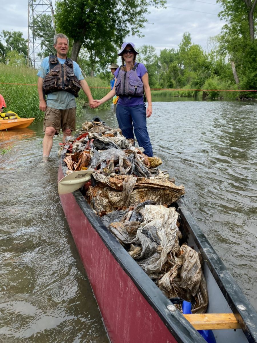 Couple by canoe full of trash