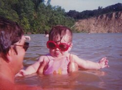 Megan McDowell as a baby swimming in a sand quarry with her dad