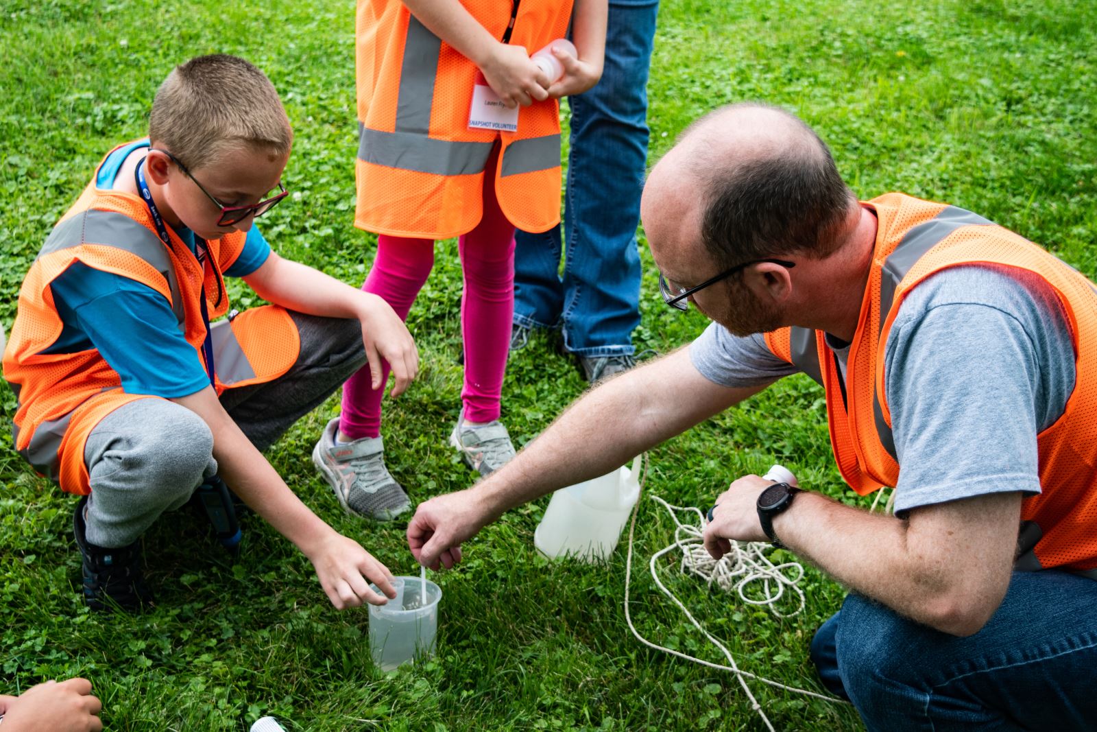 Volunteers Ethan Frye (L) and father Jonathan Frye (R) conduct water quality tests