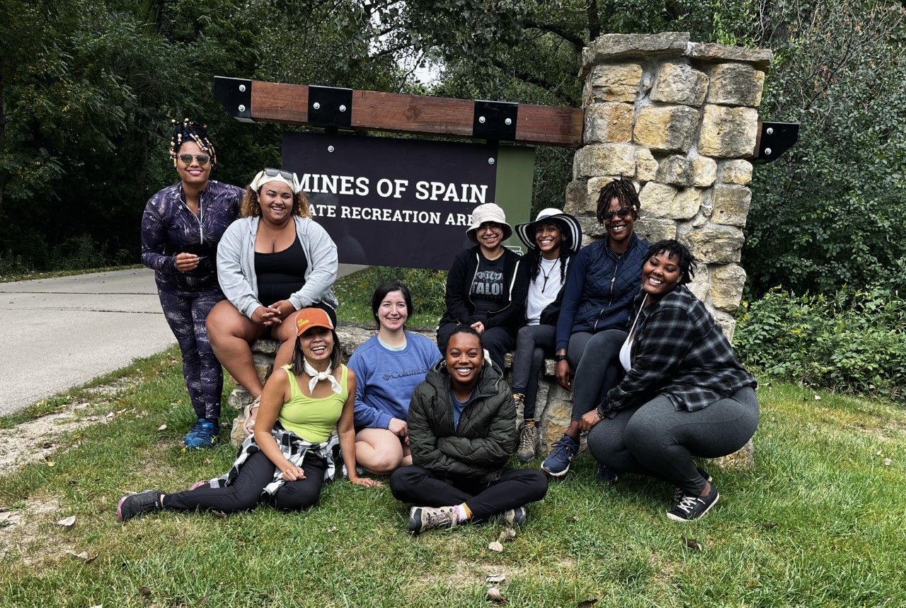 Group posing by Mines of Spain Rec Area Sign