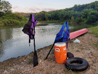 Canoe, inner tube, paddles and water cooler on a sandbar