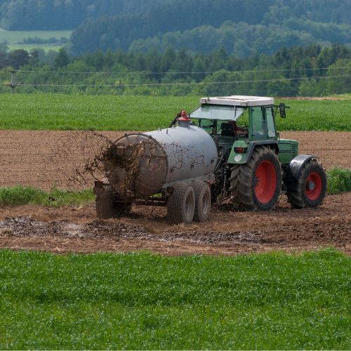 tractor spreading manure on field