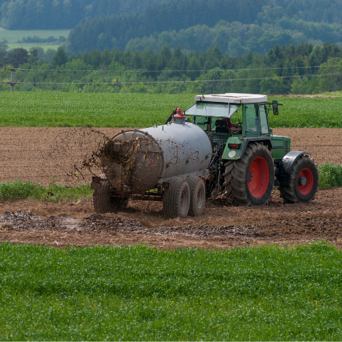 Tractor spreading manure on field