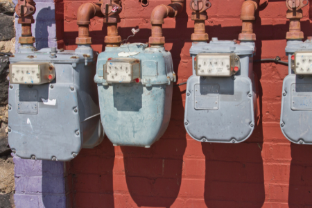 utility meters along a brick wall